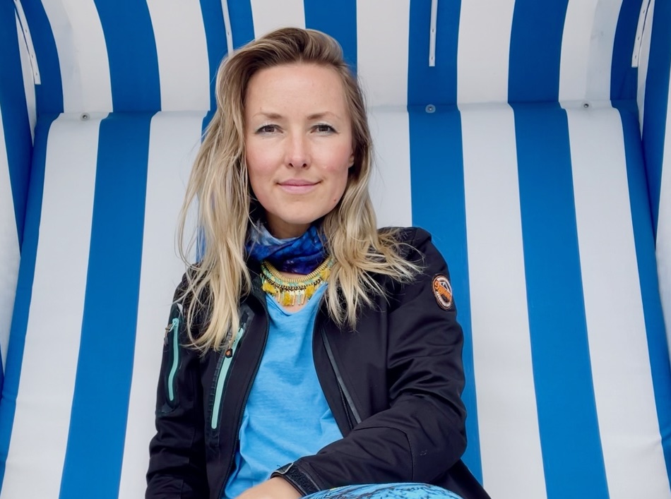 Portrait of the site owner seated in front of a blue-and-white striped background